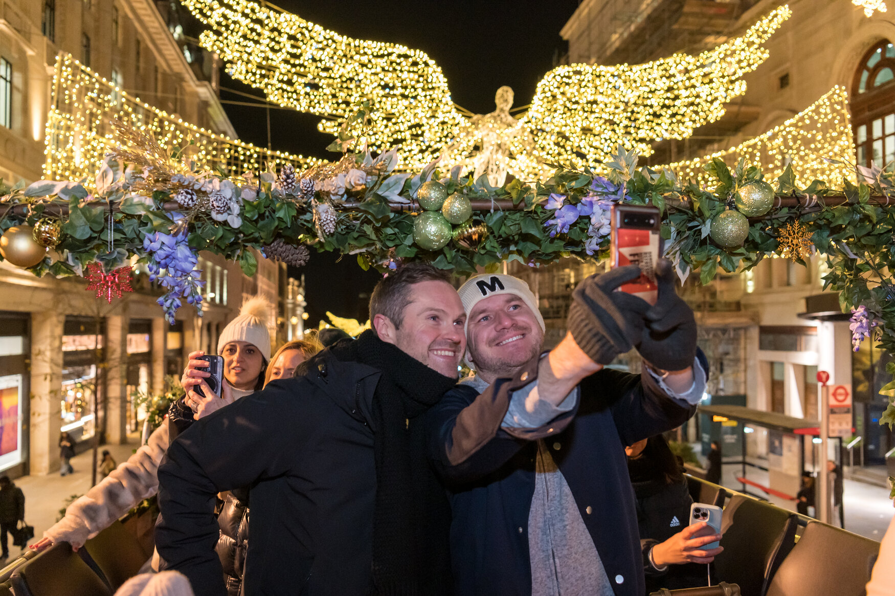 Happy friends taking a selfie on the Bar Bus at Christmas by Tootbus