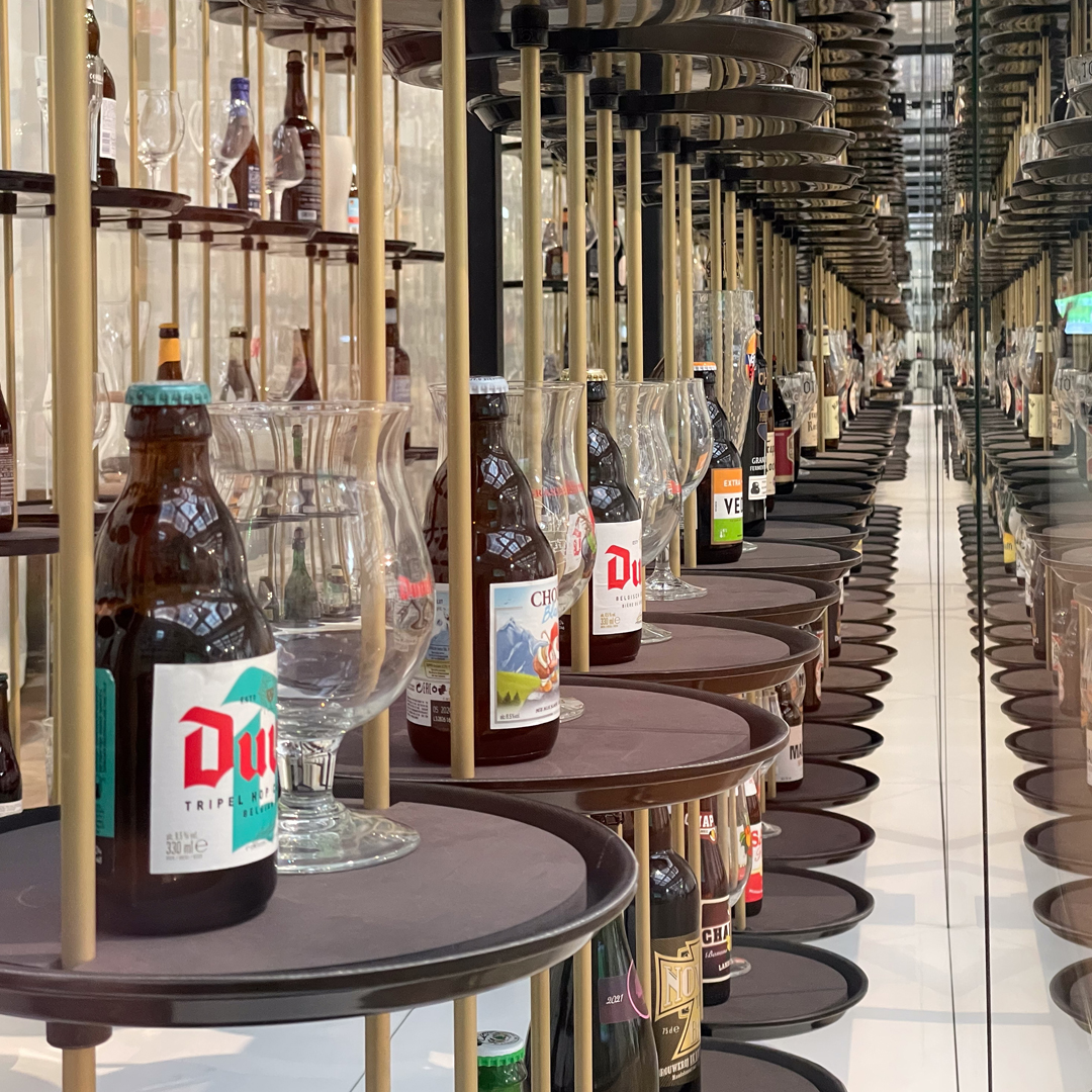 Detailweergave van een moderne kunstinstallatie in het Belgian Beer World museum in de Beurs van Brussel, met een oneindig perspectief van Belgische bierflesjes en glazen op hangende dienbladen weerspiegeld in de spiegels, met de nadruk op het bestand image_d93dc4.jpg.