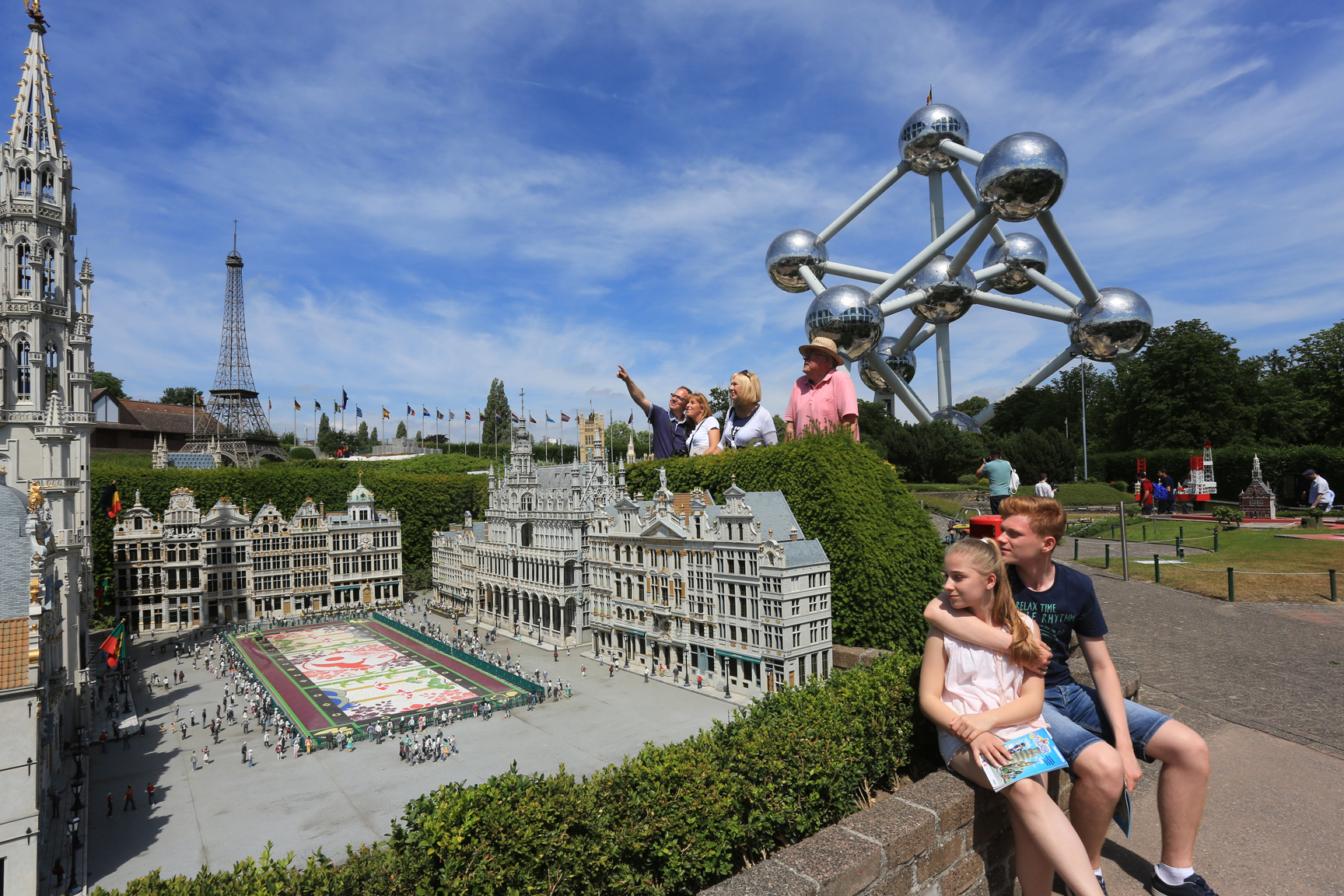 Visitors in front of Mini-Europe miniatures with the Atomium in the background.