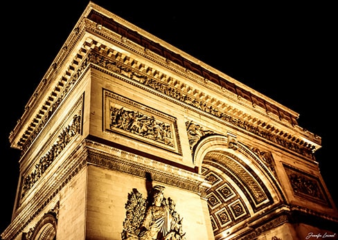 Vue nocturne de la Seine à Paris avec les reflets dorés des monuments illuminés, l'Institut de France à gauche et la Tour Eiffel au loin.