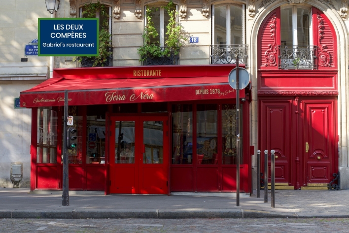 Red storefront of the Italian restaurant Terra Nera in Paris, known as "Les Deux Compères" in the Emily in Paris series.