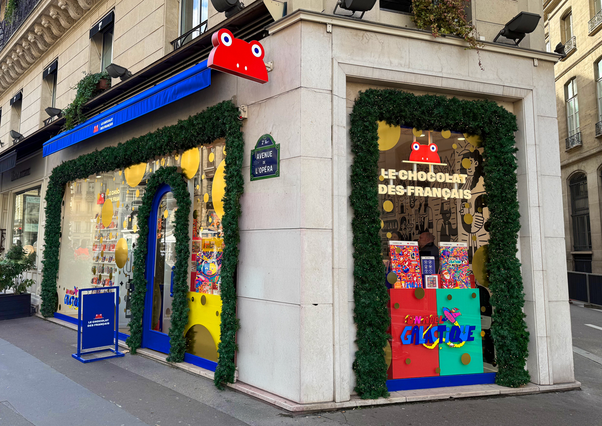 The colorful and decorated storefront of the Le Chocolat des Français boutique on the corner of Avenue de l'Opéra in Paris.