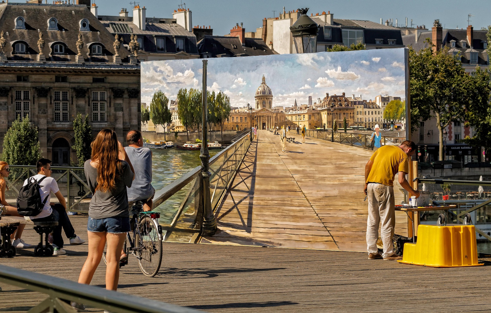 An artist paints on a large canvas set up on the Pont des Arts in Paris, watched by passersby.
