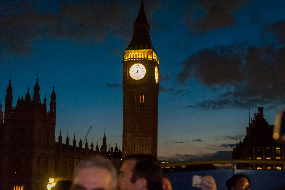 Vue nocturne de la tour du Big Ben illuminée à Londres depuis l'étage supérieur d'un bus décapotable au crépuscule.